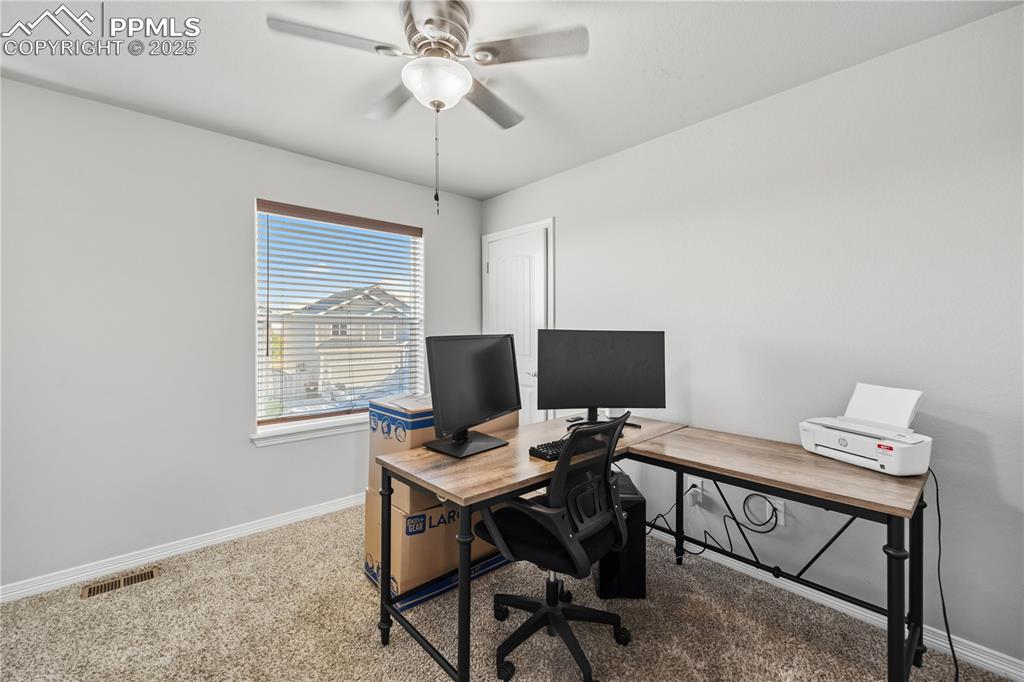 Image 24 of 33: Carpeted home office with baseboards and a ceiling fan