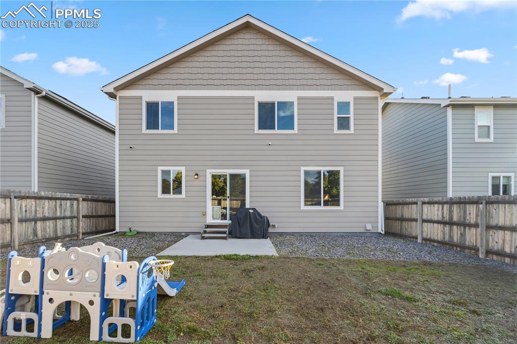 Image 31 of 33: Rear view of property featuring a patio, a fenced backyard, and entry steps