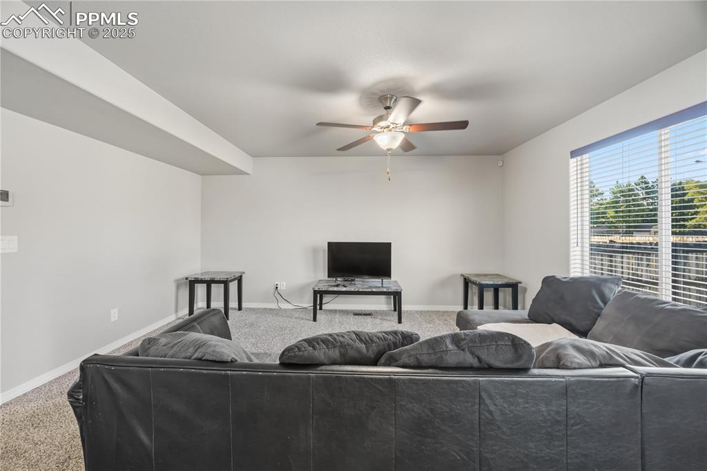 Image 7 of 33: Carpeted living room with baseboards and a ceiling fan
