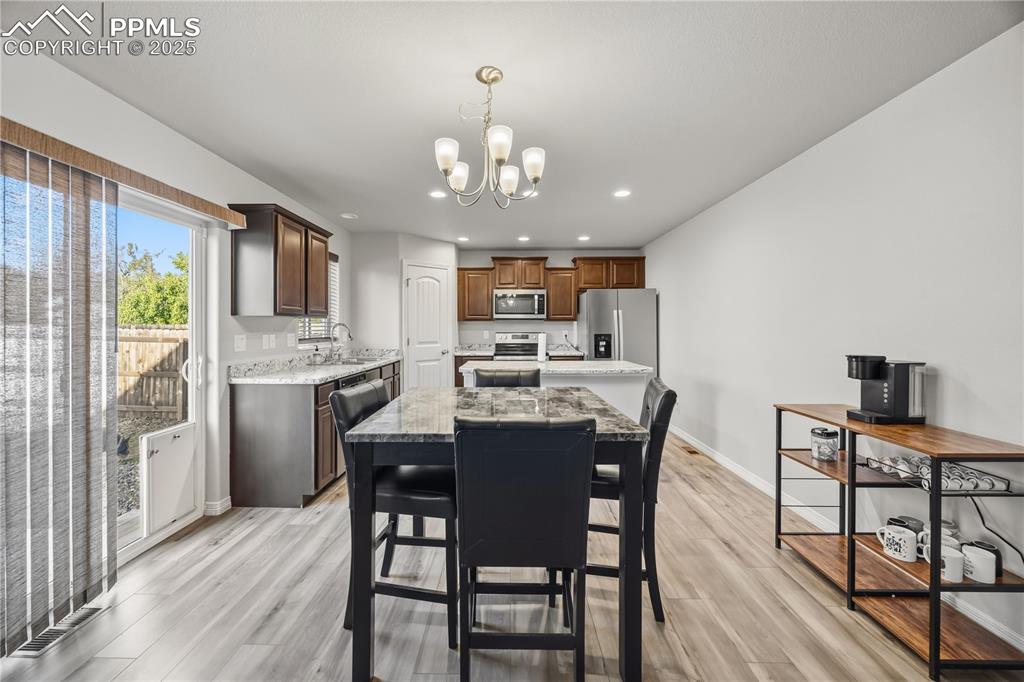 Image 9 of 33: Dining room featuring light wood-style floors, a chandelier, and recessed l