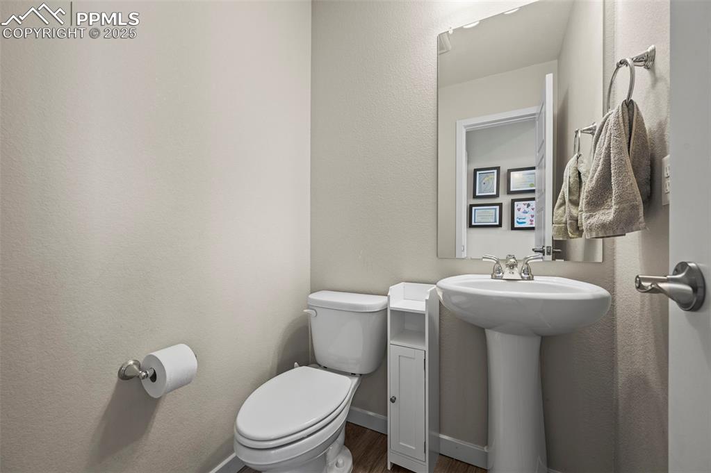 Image 13 of 44: Half bath with toilet and wood finished floors
