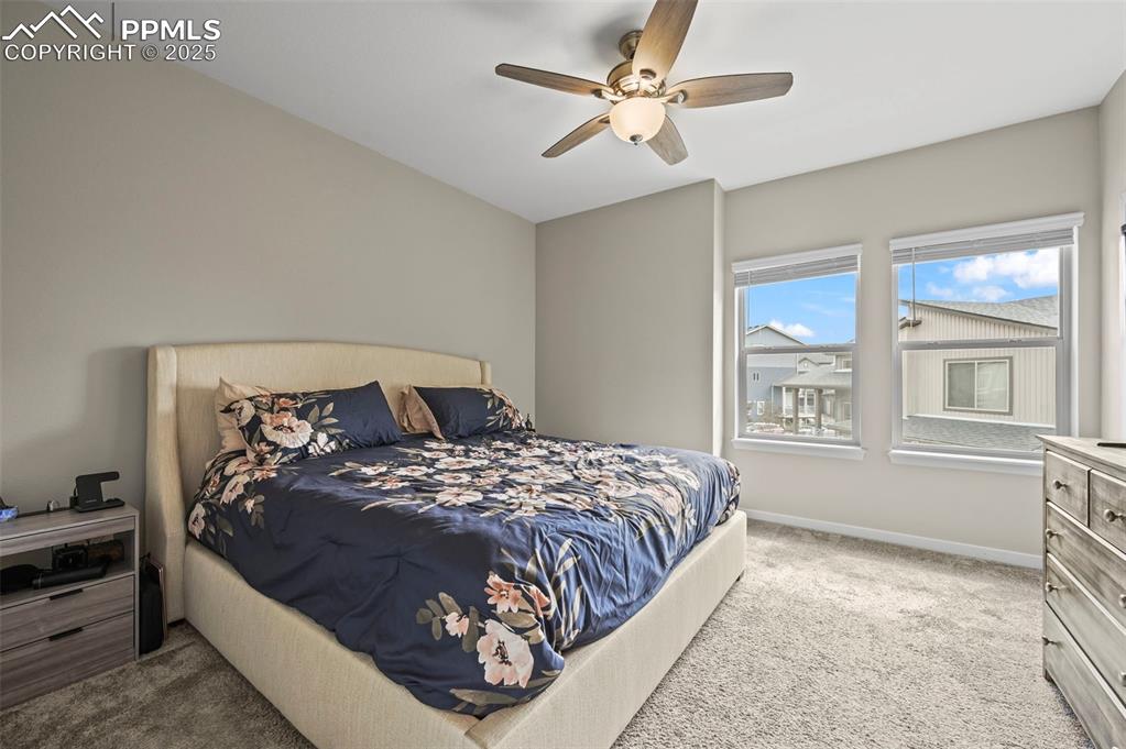 Image 14 of 44: Carpeted bedroom featuring a ceiling fan and baseboards