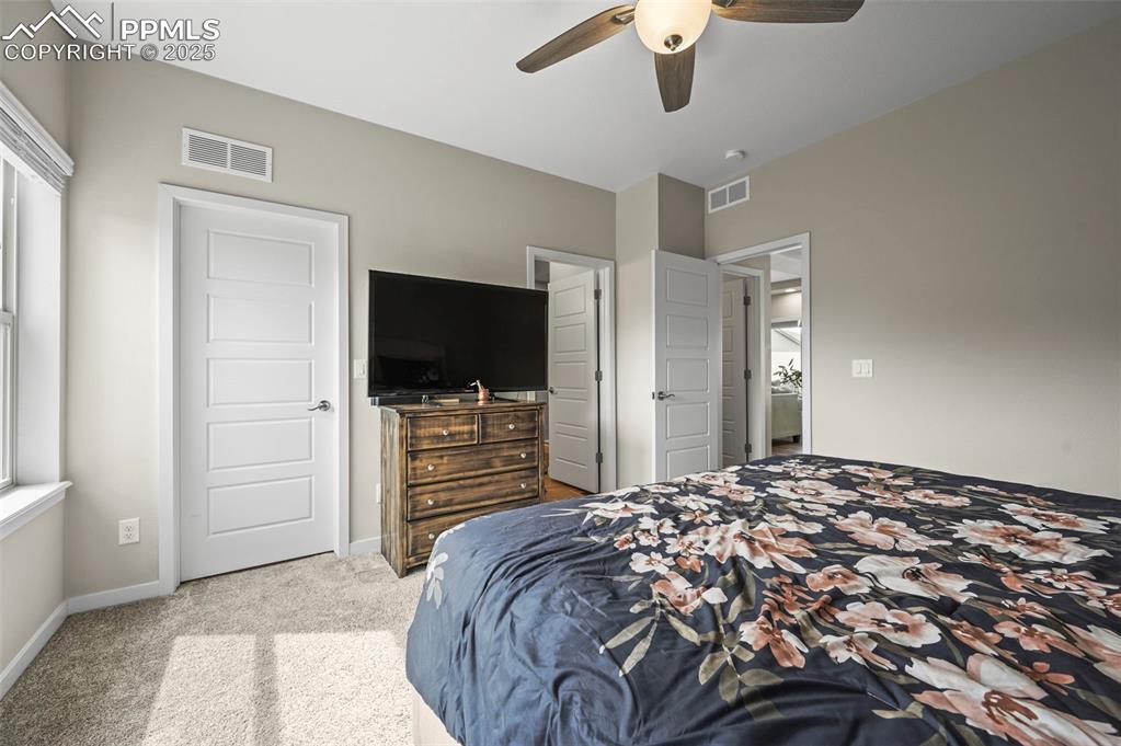 Image 15 of 44: Carpeted bedroom with baseboards and a ceiling fan