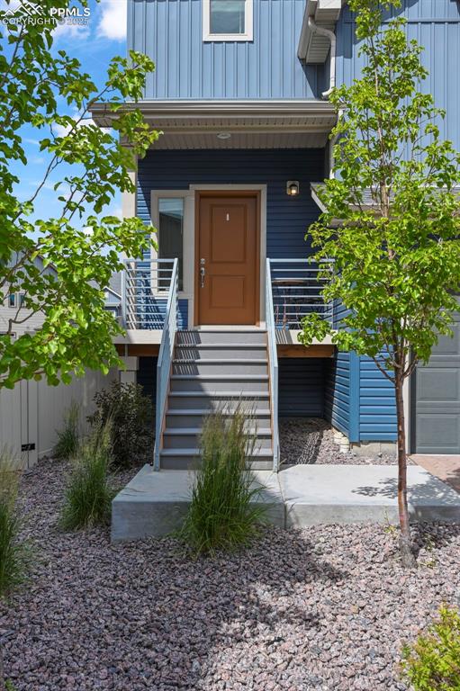 Image 2 of 44: Doorway to property featuring board and batten siding and covered porch