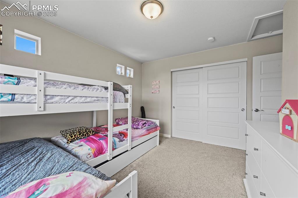 Image 24 of 44: Bedroom featuring light carpet, a closet, and multiple windows