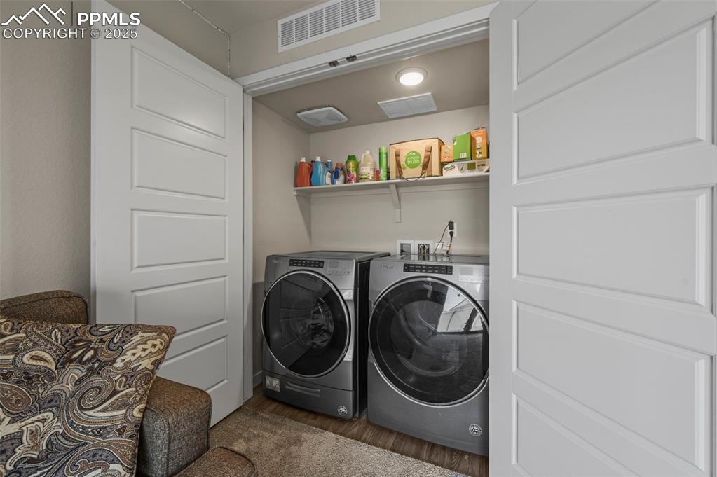 Image 33 of 44: Washroom with dark wood-type flooring and separate washer and dryer