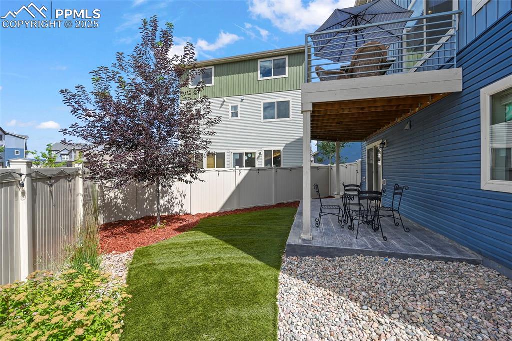 Image 35 of 44: Fenced backyard with a patio area