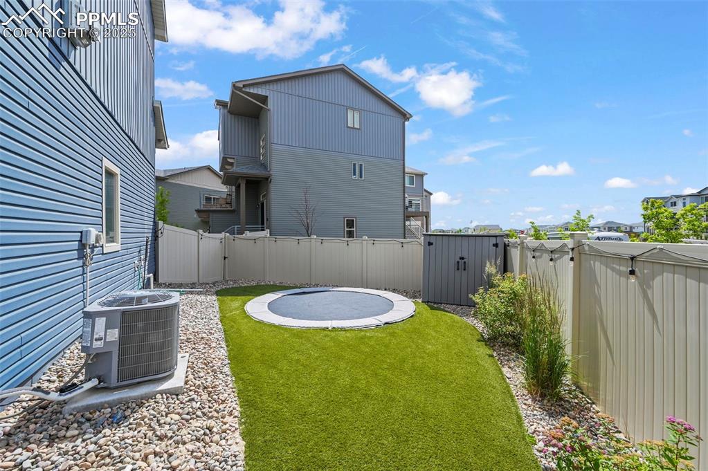 Image 36 of 44: Fenced backyard with a shed and a residential view