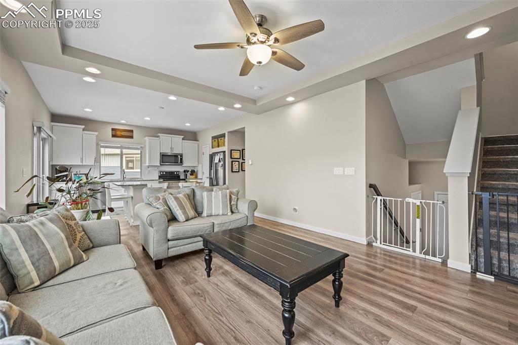 Image 6 of 44: Living room with wood finished floors, ceiling fan, and recessed lighting