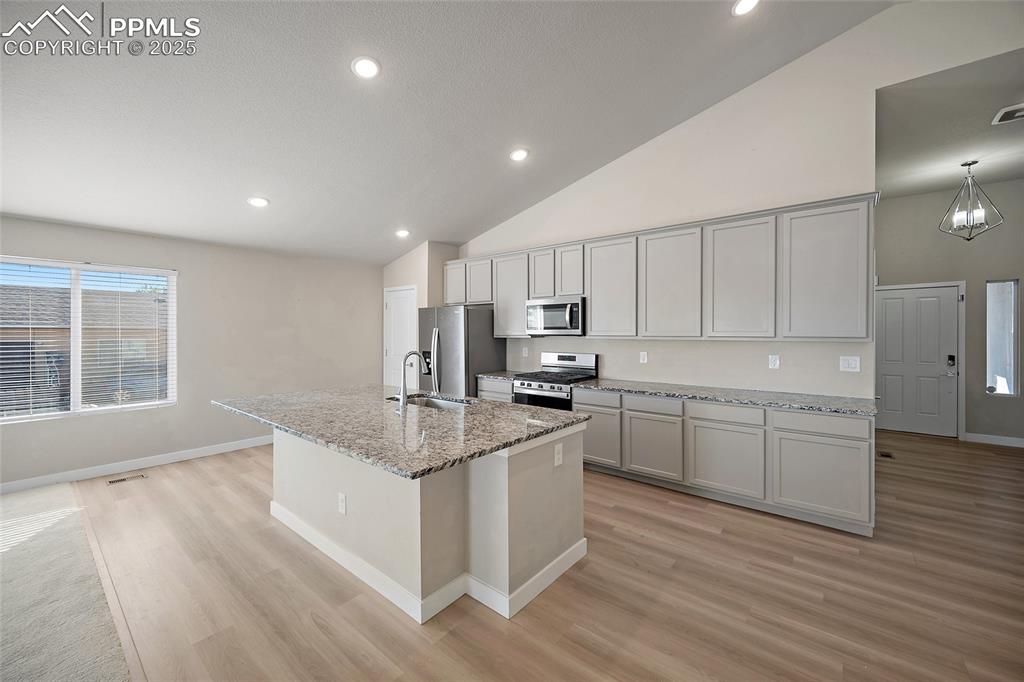 Image 13 of 30: Kitchen with a center island with sink, stainless steel appliances, recesse