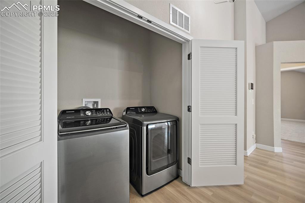 Image 16 of 30: Laundry room featuring light wood-style floors and washing machine and clot