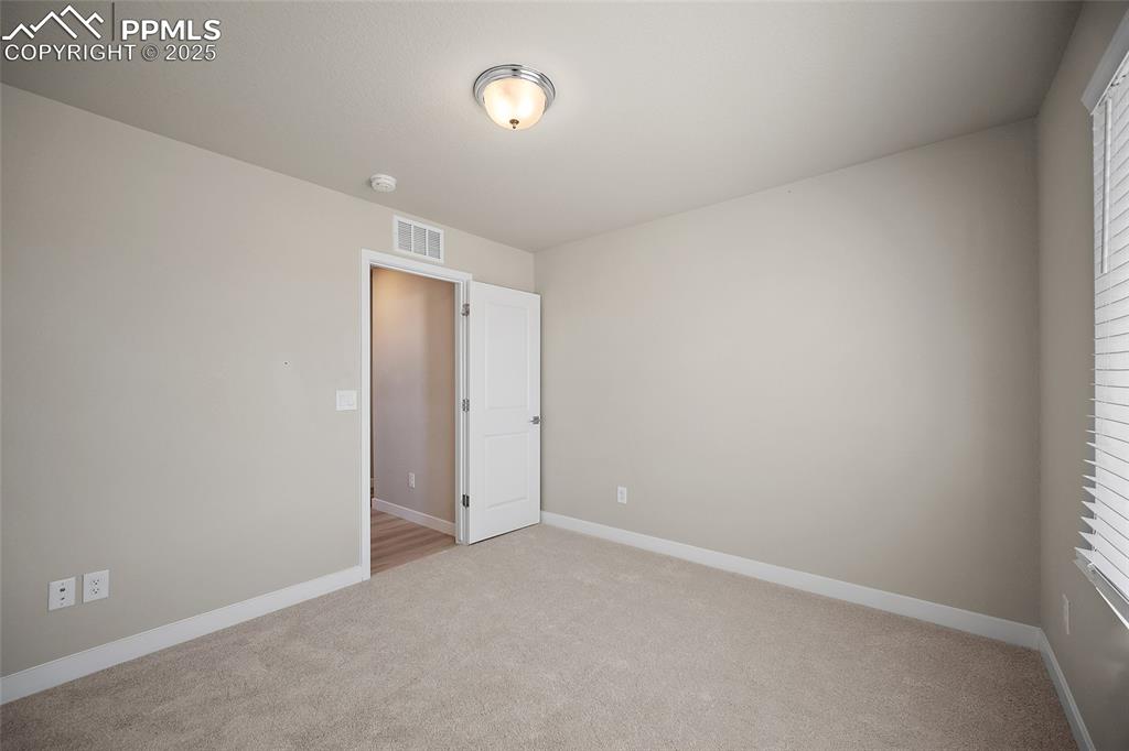 Image 24 of 30: Spare room with light colored carpet and baseboards