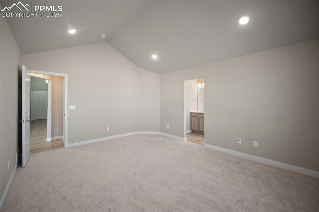 Image 26 of 30: Unfurnished bedroom featuring light colored carpet, lofted ceiling, and rec