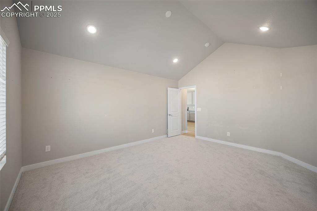 Image 27 of 30: Empty room featuring light colored carpet, recessed lighting, and high vaul