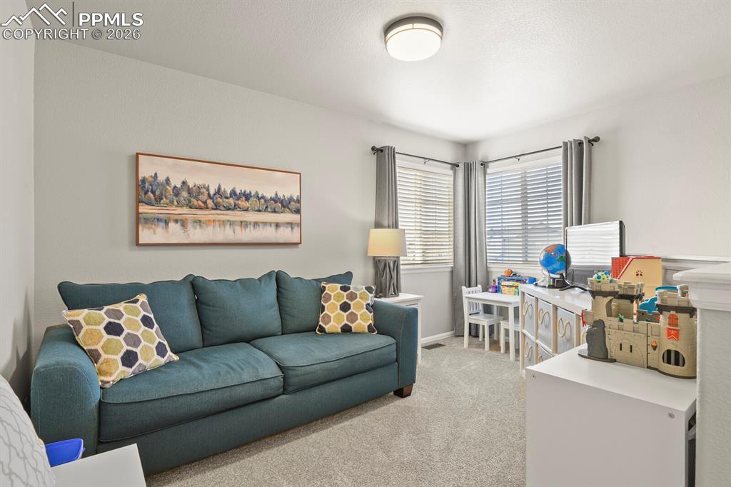 Image 27 of 40: Living room with light colored carpet and baseboards