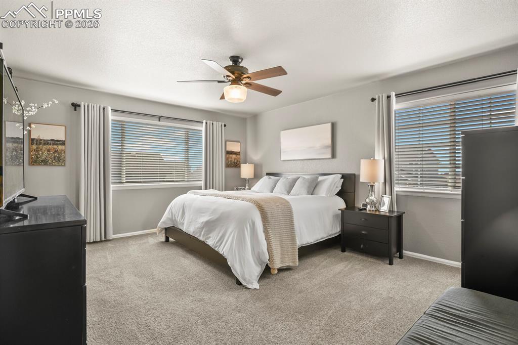 Image 29 of 40: Bedroom featuring light colored carpet, ceiling fan, and a textured ceiling