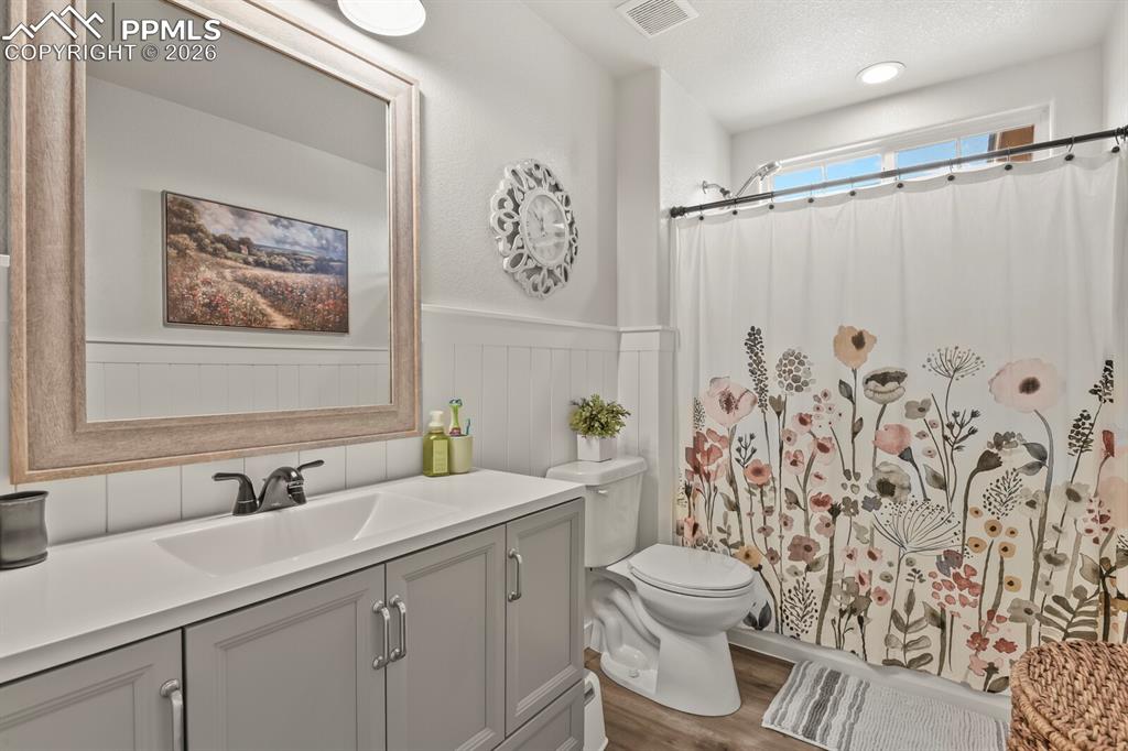 Image 34 of 40: Full bathroom featuring vanity, dark wood-style flooring, a shower with cur