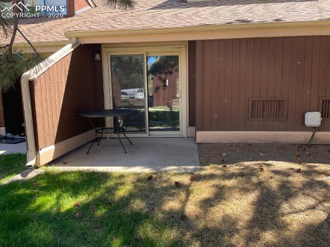 Image 25 of 28: Patio off of Living Room with Storage closet and small garden area
