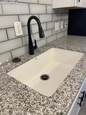Image 5 of 28: Deep, stone kitchen sink with updated faucet