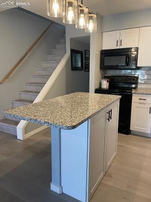 Image 6 of 28: Kitchen island with breakfast bar and more storage.