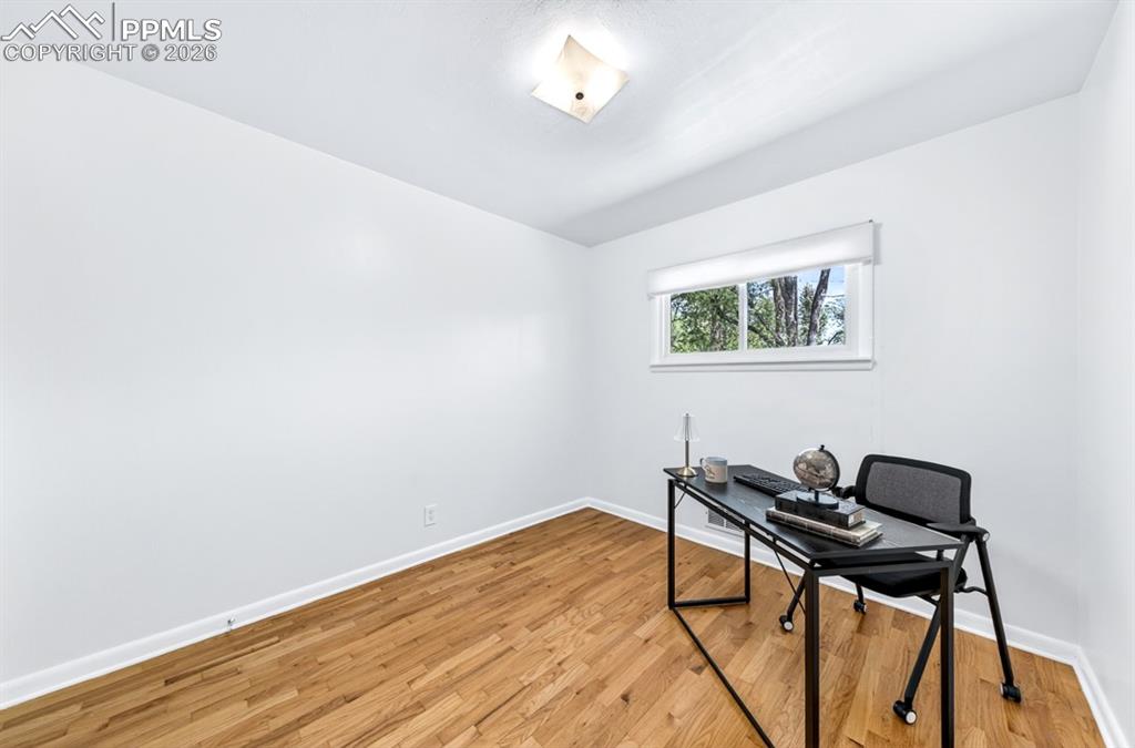 Image 35 of 46: Hardwood flooring in a room featuring white walls and trim