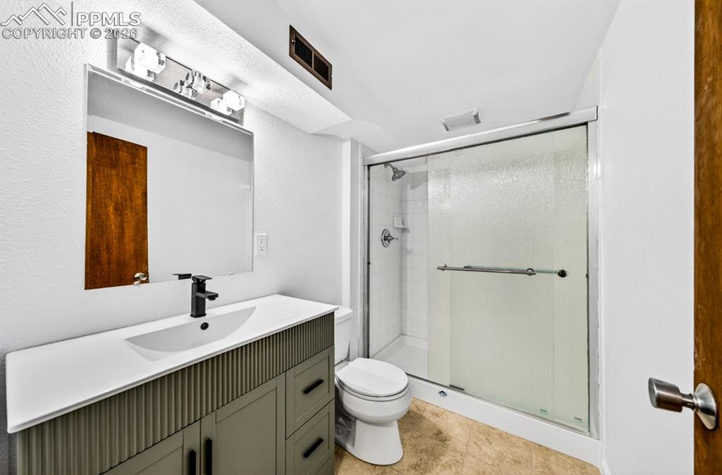 Image 36 of 46: Hardwood flooring, white painted walls, and a window with a roller shade