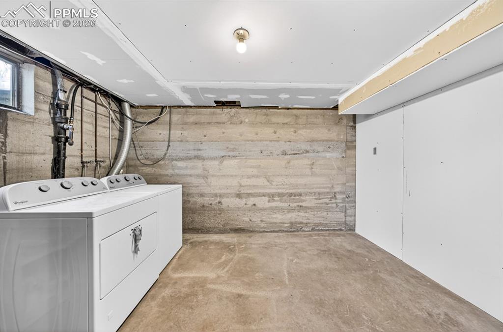 Image 39 of 46: Expansive lower-level space featuring a window, white painted walls, a wood