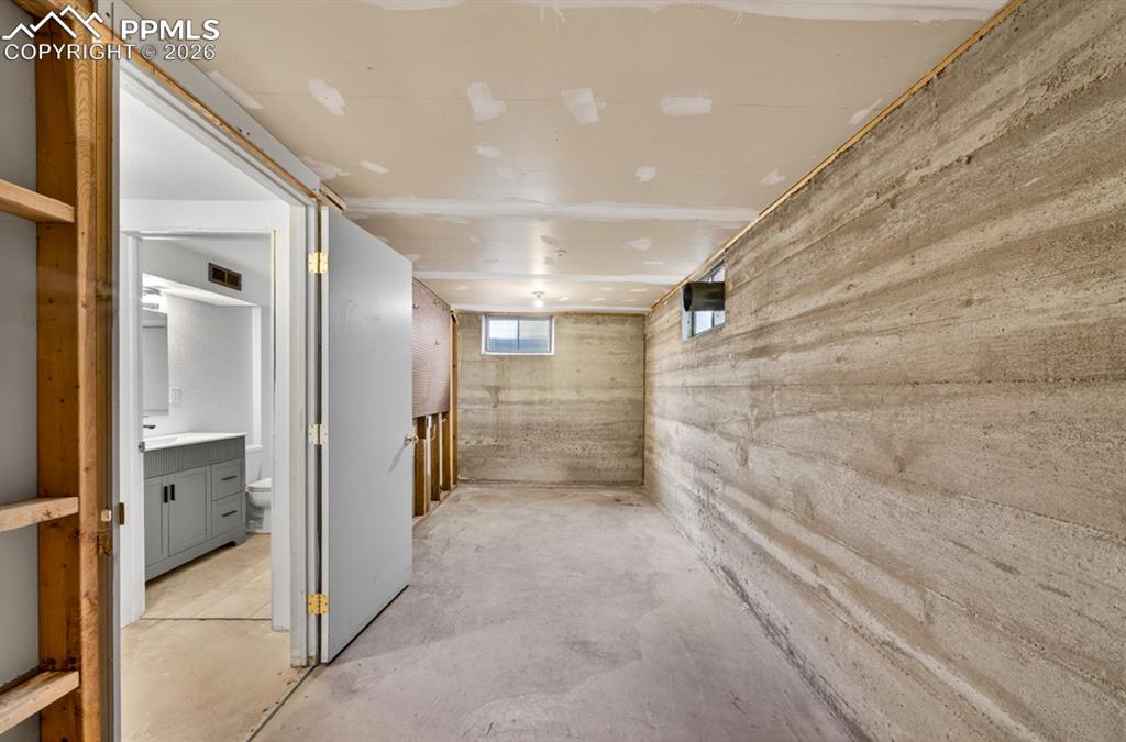 Image 40 of 46: Utility area featuring concrete flooring, exposed concrete walls, partially