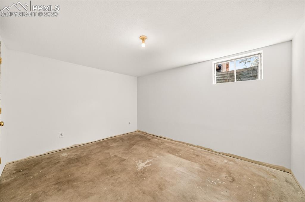 Image 42 of 46: Interior room featuring painted white walls, a bare concrete floor, and a c