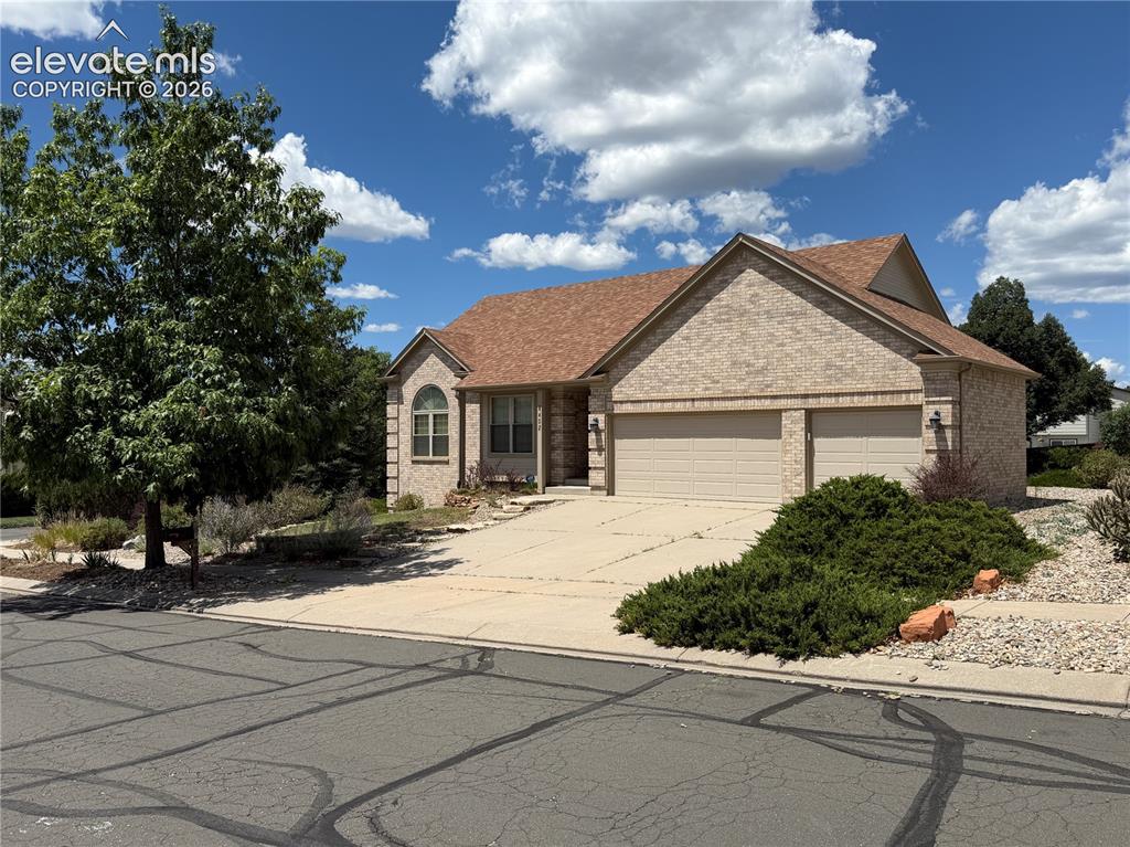 Caption: Brick exterior with a peaked roofline, featuring a two-car garage with separate doors