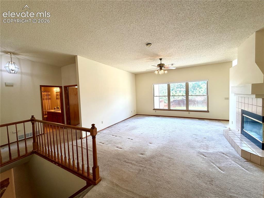 Image 12 of 50: Spacious living area featuring a vaulted ceiling and an expansive window