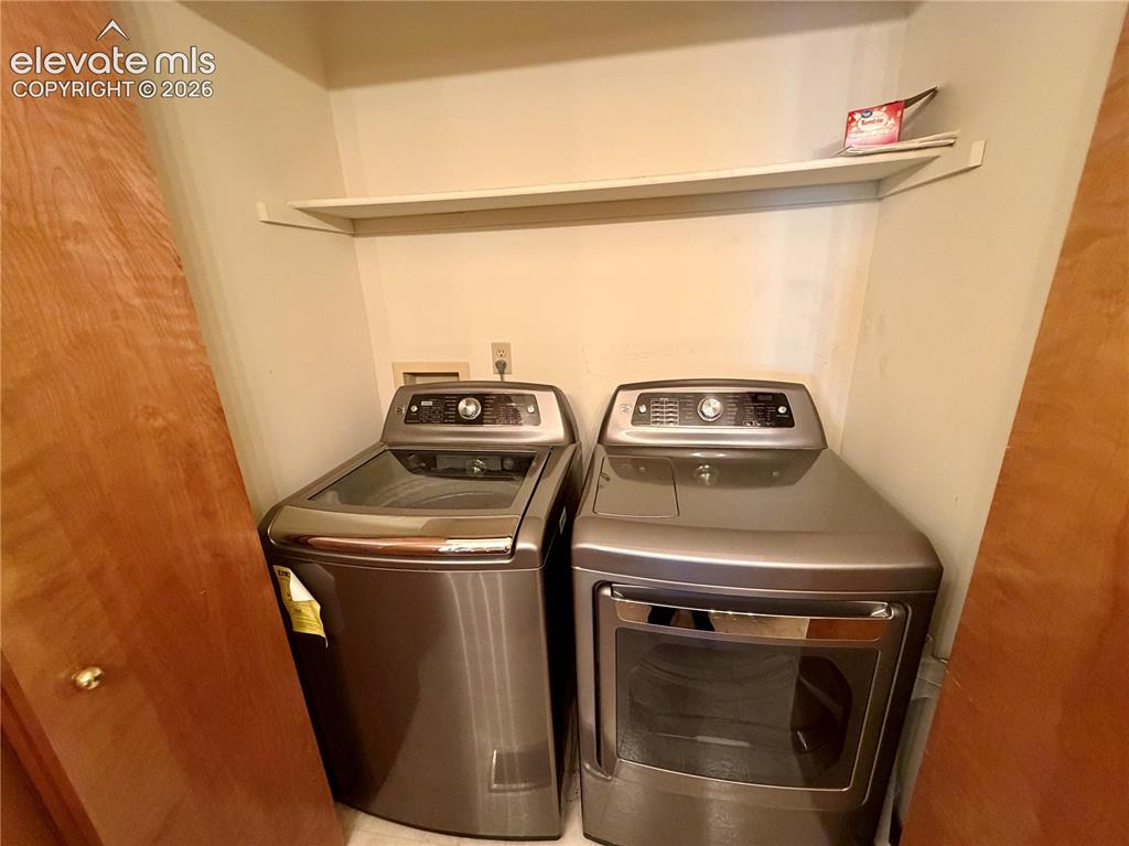 Image 28 of 50: Dedicated laundry area featuring a built-in shelf, neutral wall tones, and