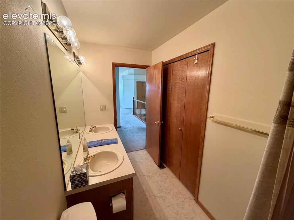 Image 29 of 50: Bathroom featuring a double vanity with integrated sinks, a large wall-moun