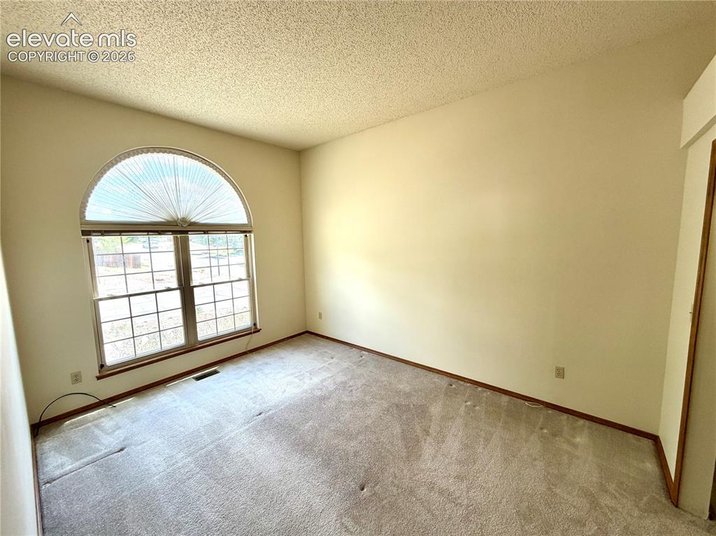 Image 32 of 50: Room with light-colored walls and textured ceiling
