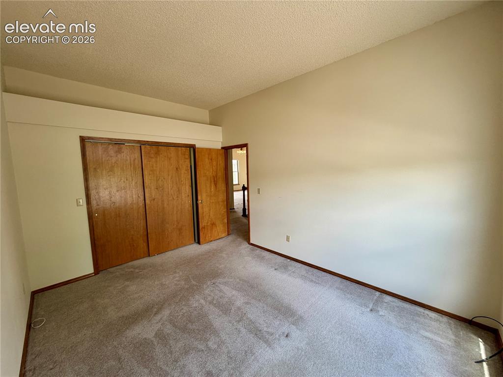 Image 34 of 50: Room featuring light-toned walls, textured ceiling, and gray carpet floorin