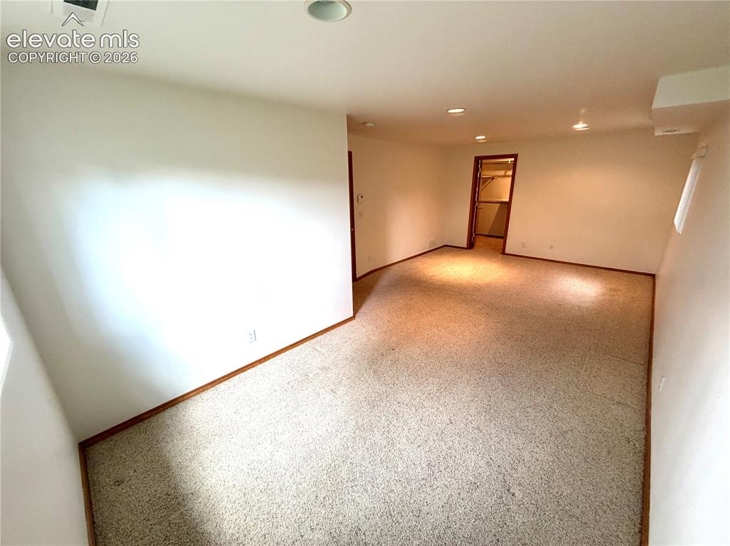 Image 40 of 50: Spacious room featuring neutral carpet and white walls