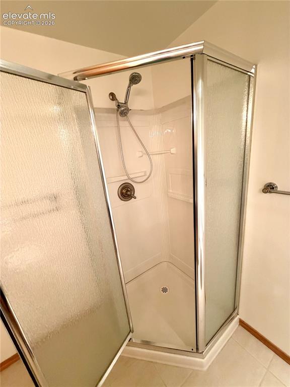 Image 41 of 50: Corner shower enclosure featuring textured glass panels and chrome-finish f