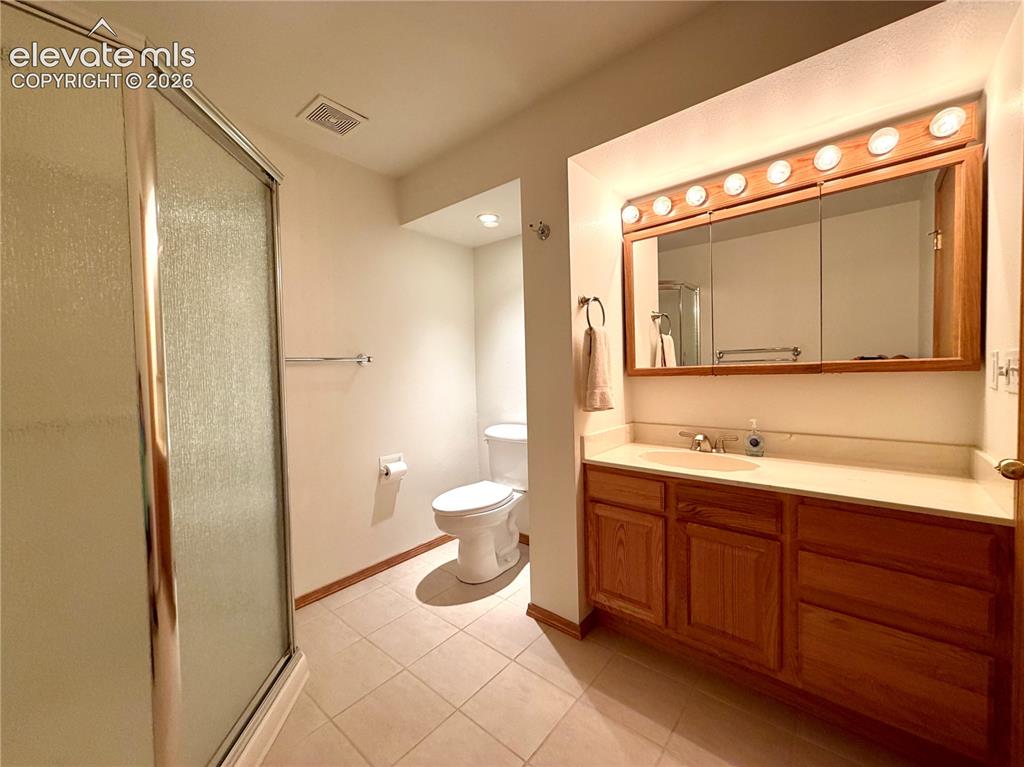 Image 42 of 50: Bathroom featuring a full vanity with wood cabinetry, a built-in sink, and
