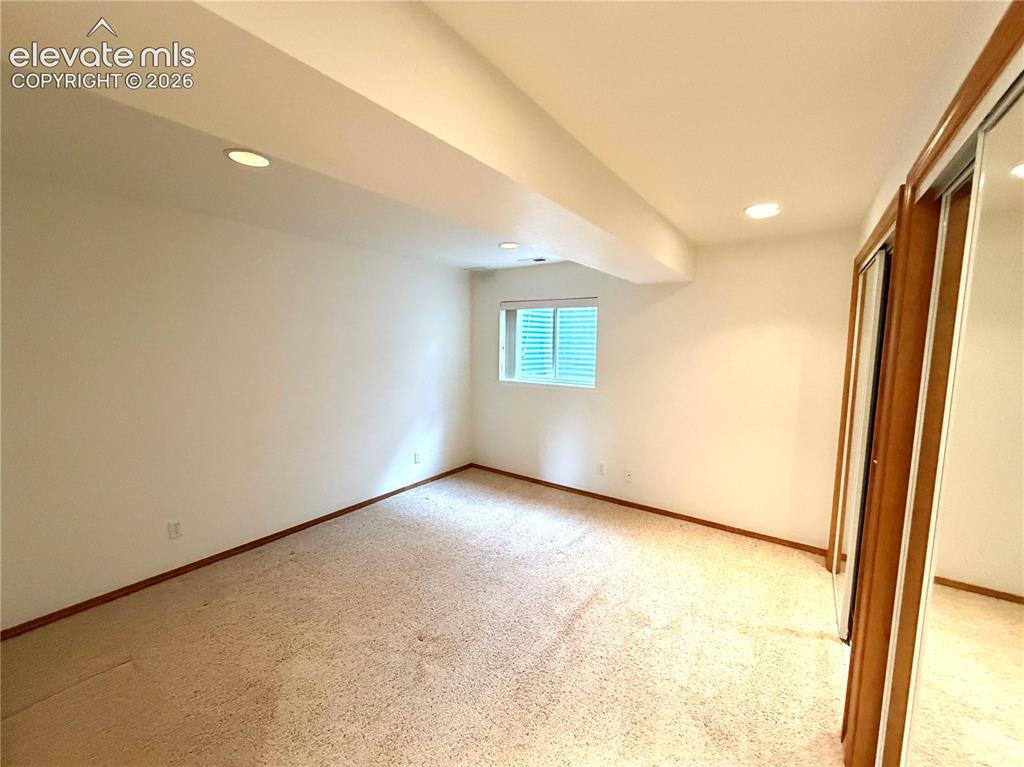 Image 48 of 50: Carpeted interior space featuring recessed lighting, a window with horizont