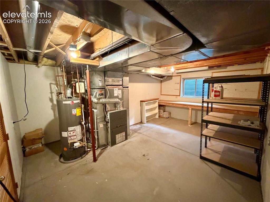 Image 50 of 50: Unfinished basement with concrete flooring, exposed ceiling joists, and a u