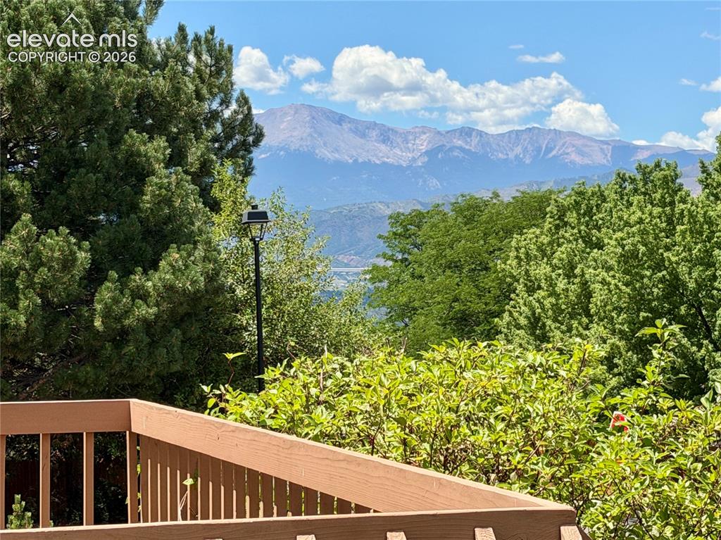 Image 6 of 50: Expansive mountain range backdrop with a deep blue sky and scattered white