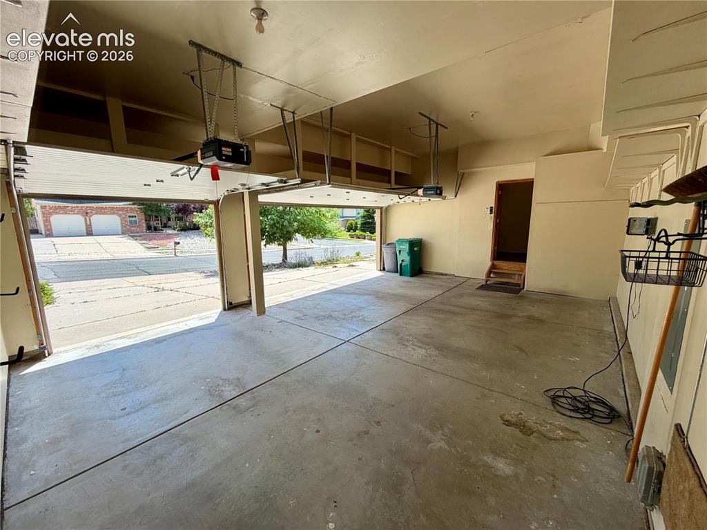 Image 8 of 50: Two-car garage featuring concrete flooring, automatic garage door openers,