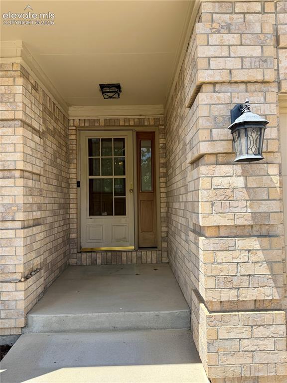 Image 9 of 50: Brick exterior featuring a covered entry