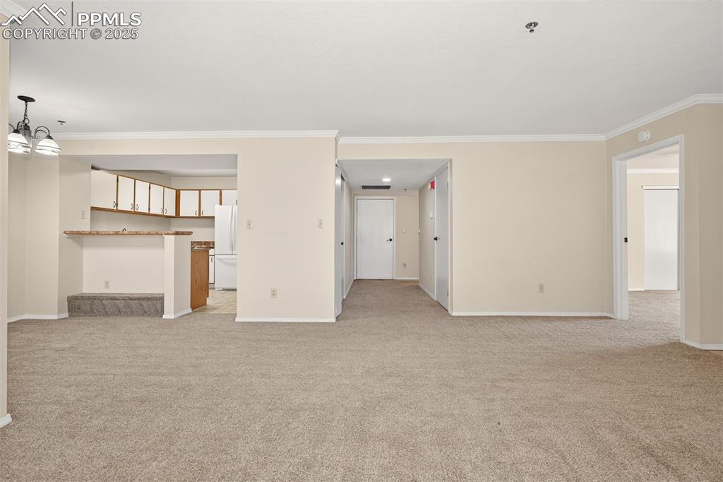 Image 13 of 27: Looking down the hall to Bedrooms and door to the garage