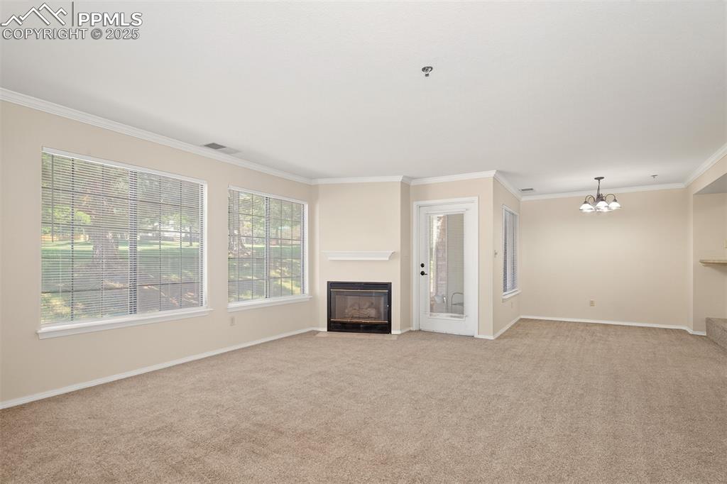 Image 3 of 27: Large windows, fire place and door to the patio