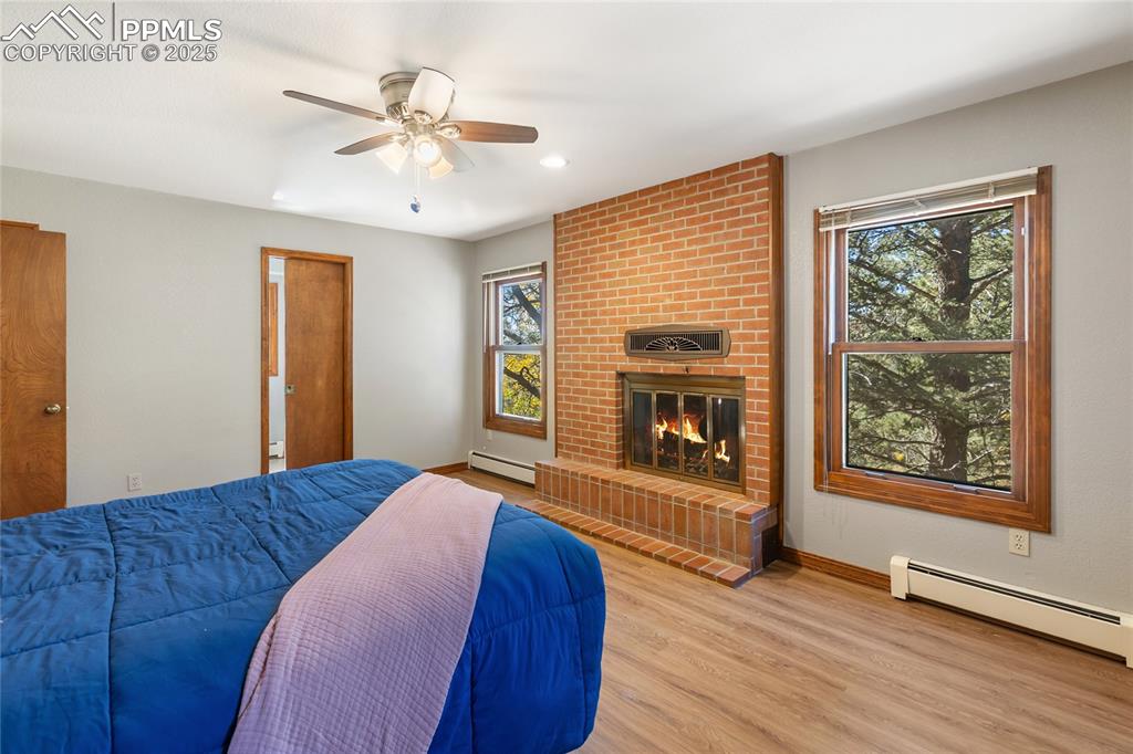 Image 22 of 50: Upper level primary bedroom with wood burning fireplace, ensuite and LVP fl