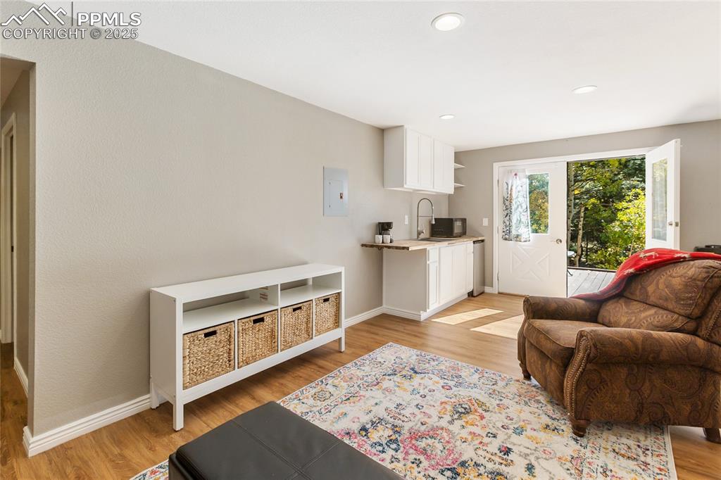 Image 39 of 50: Basement family room walk out to deck, wet bar with sink and mini fridge