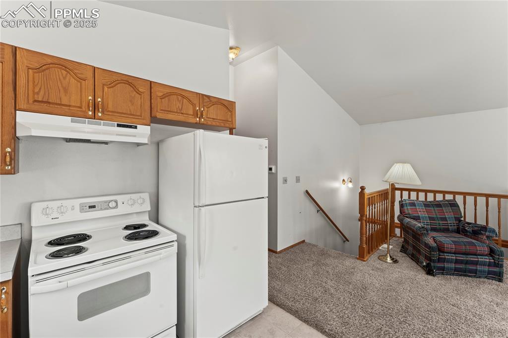 Image 12 of 36: Kitchen area and view of stairs to lower level