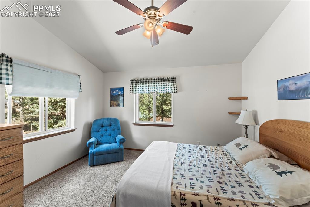 Image 17 of 36: Carpeted bedroom featuring vaulted ceiling and a ceiling fan
