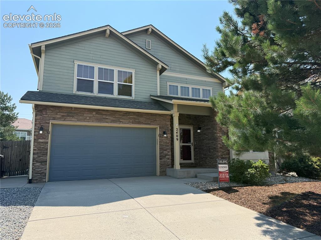 Image 1 of 28: Two-story residence featuring a covered entry, stone facade accents, a two-